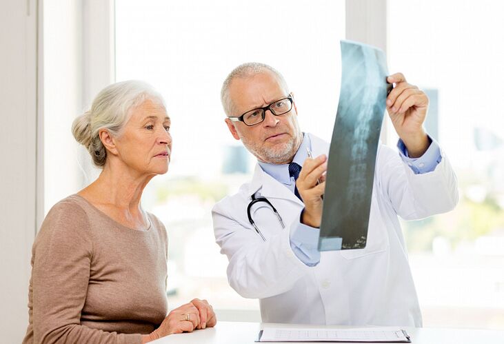 Lekár určuje cervikálnu osteochondrózu u pacienta pomocou rádiografie